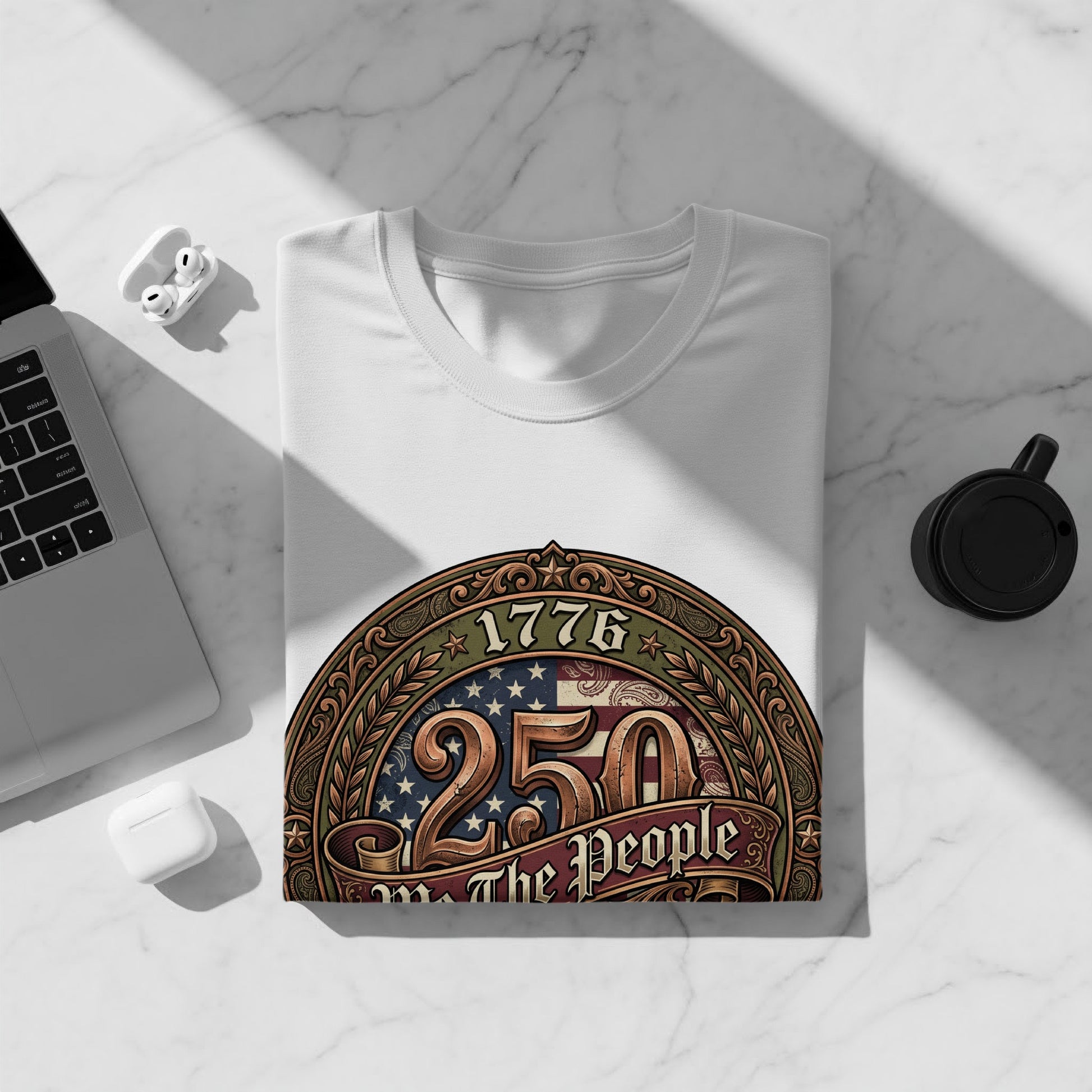 White t-shirt with "1776 250 The People" graphic on a marble surface.