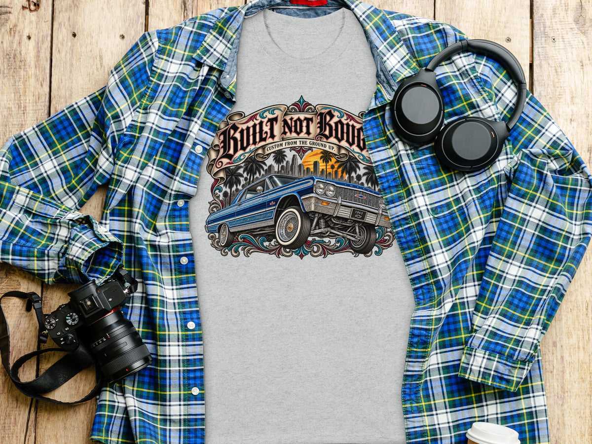 Grey t-shirt with "Built Not Bought" graphic and blue lowrider car.