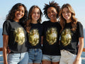 Four women model black t-shirts featuring a golden angel design.