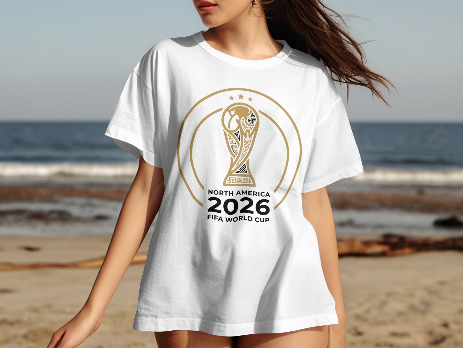 White t-shirt with 2026 FIFA World Cup trophy logo on beach background.