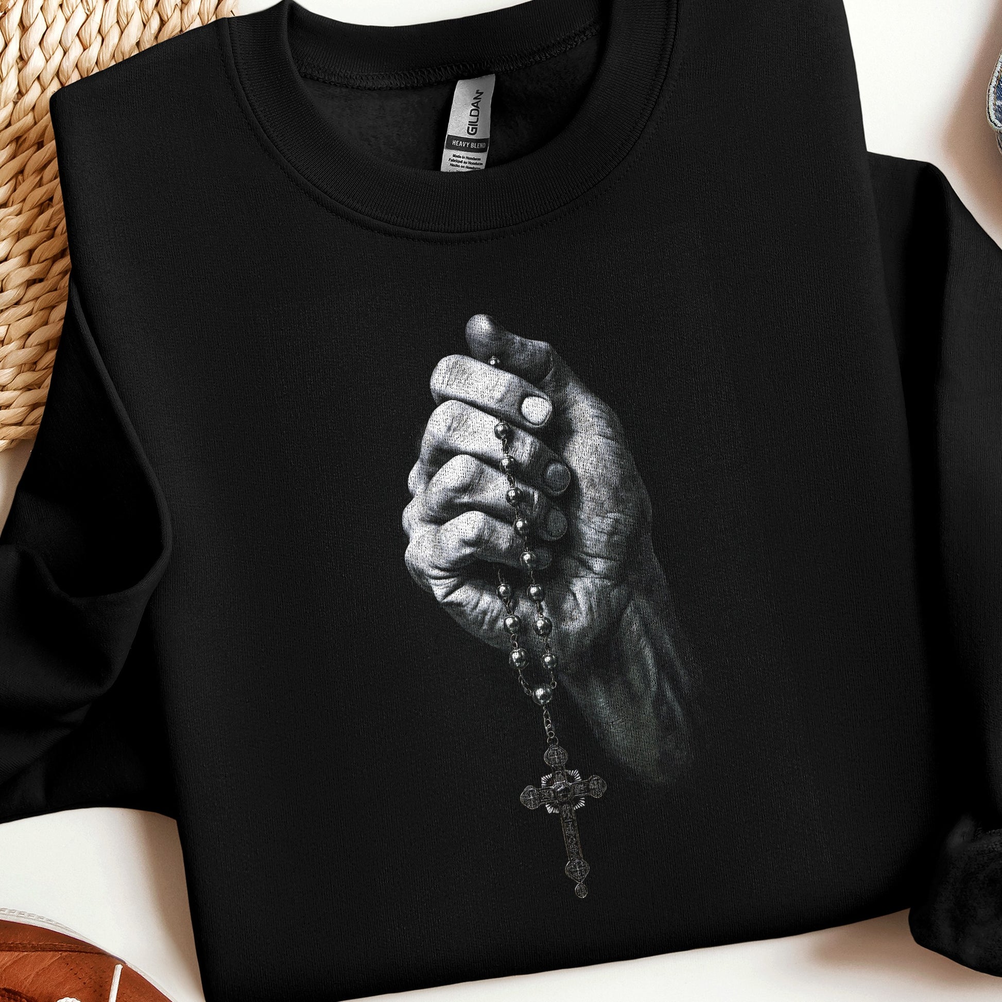 Black sweatshirt with a graphic of a hand holding a rosary.