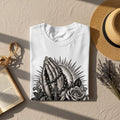 White t-shirt with praying hands, rosary, cross, and rose graphic.