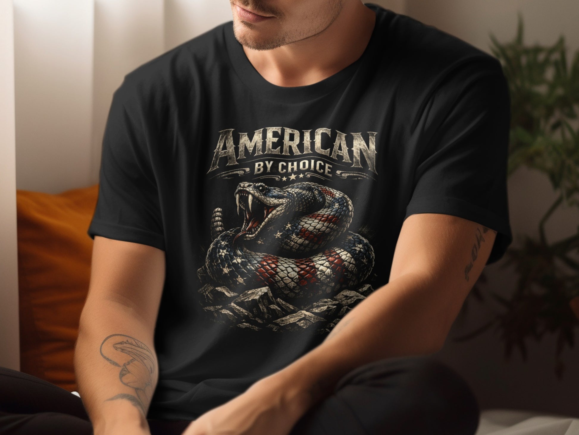Black t-shirt with patriotic snake design and "American by Choice" text.