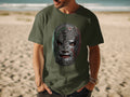 Man wearing a green t-shirt with a Mexican lucha libre mask graphic.