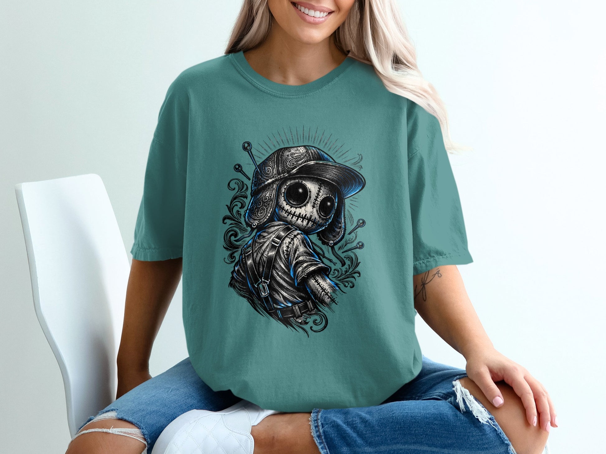 T-shirt with graphic of a dark, stitched doll wearing a baseball cap.