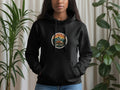 Black hoodie with circular nature graphic featuring a camper van and mountains, text reads 