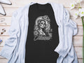 Dark t-shirt with a detailed skull and floral design, featuring the word 