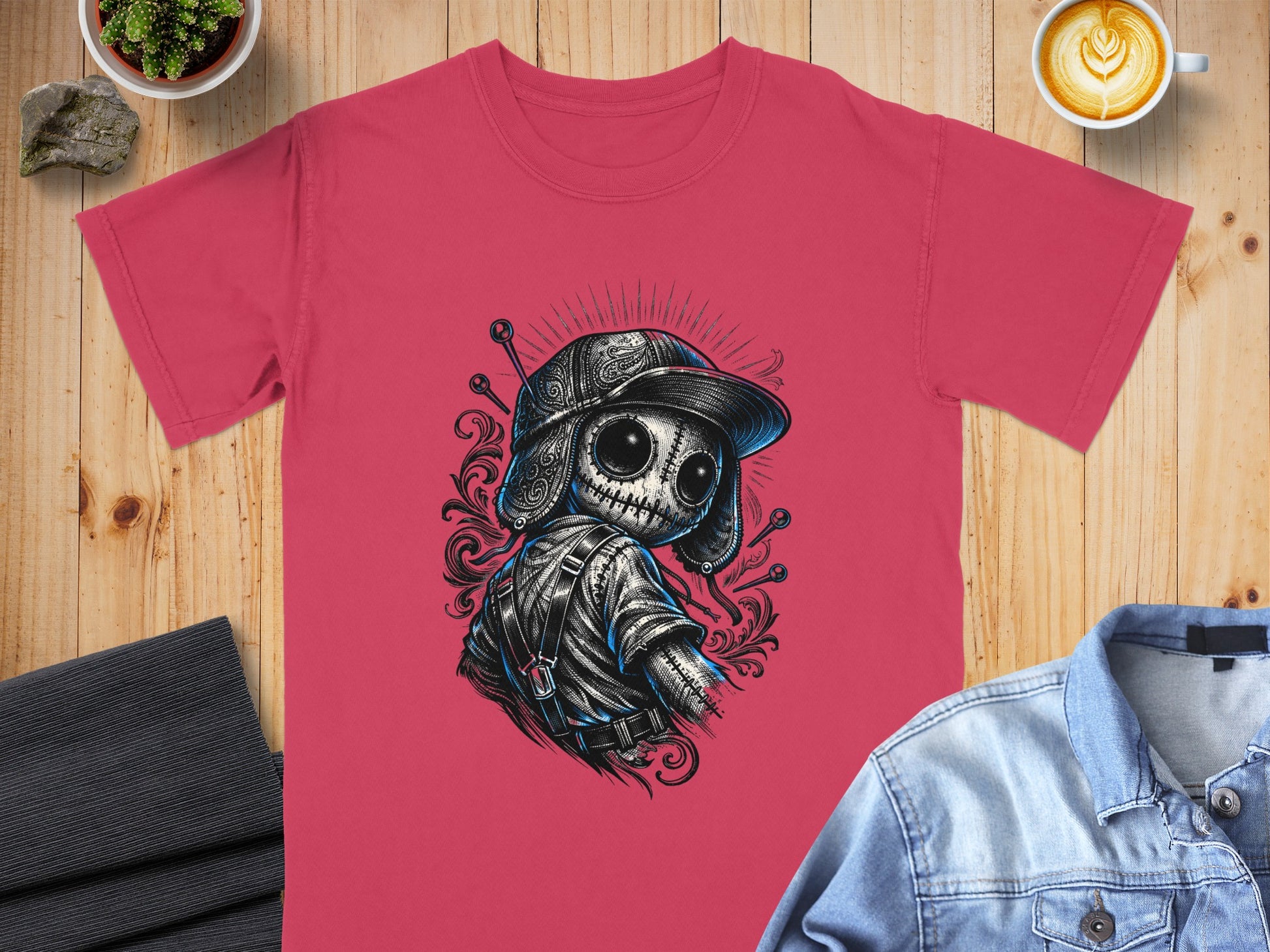 T-shirt with a stylized, spooky doll graphic wearing a hat and overalls.