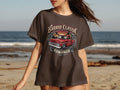 Brown t-shirt with graphic of red classic truck, palm trees, and text 