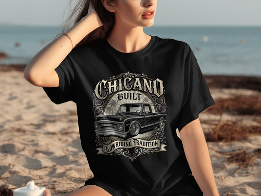 Black t-shirt with "Chicano Built Lowriding Tradition" text and a classic black pickup truck graphic.