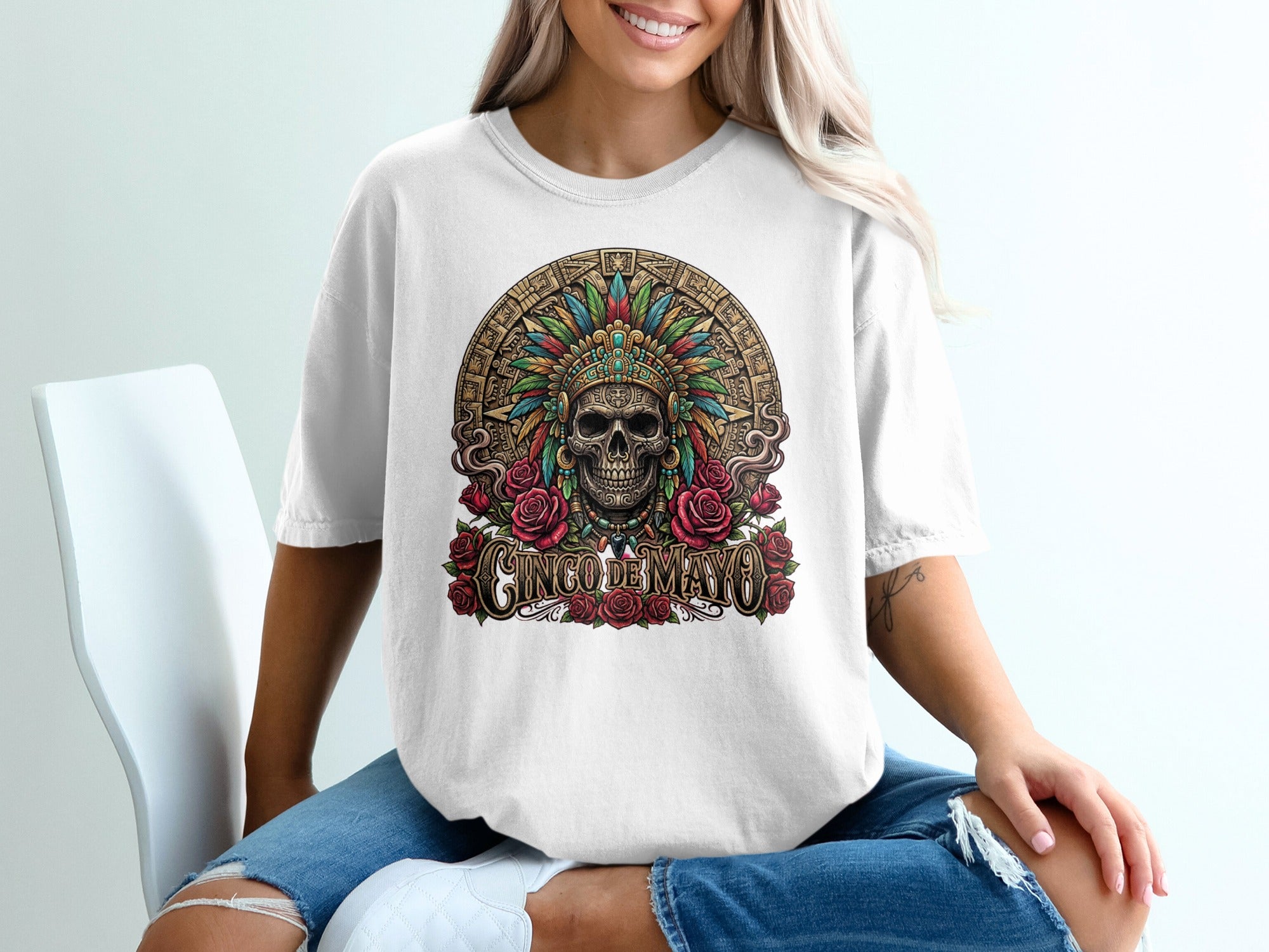 White t-shirt with a skull wearing a feathered headdress and "Cinco de Mayo" text.