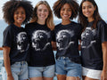 Four women wearing t-shirts featuring a detailed image of Jesus Christ on the cross.
