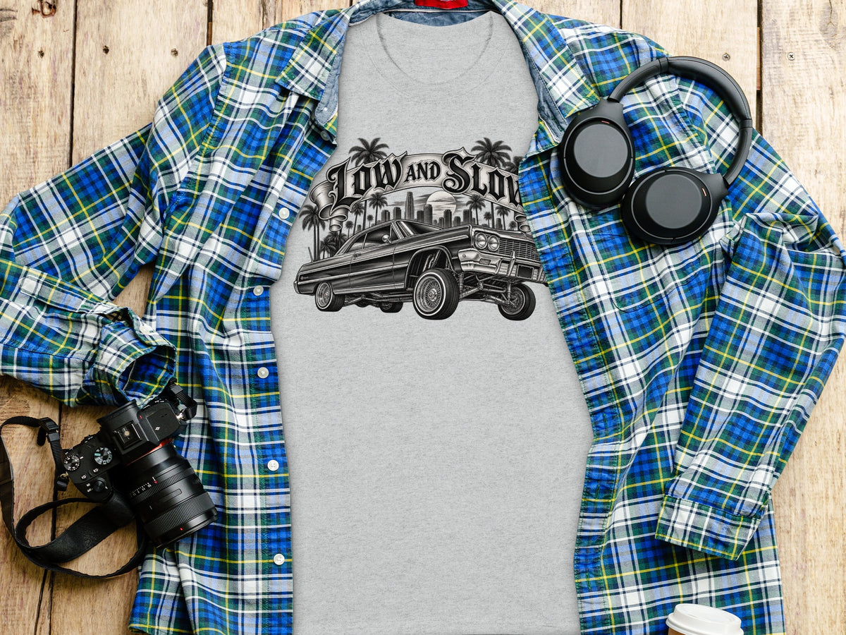 T-shirt with "Low and Slow" text and classic car graphic, laid flat with flannel shirt.
