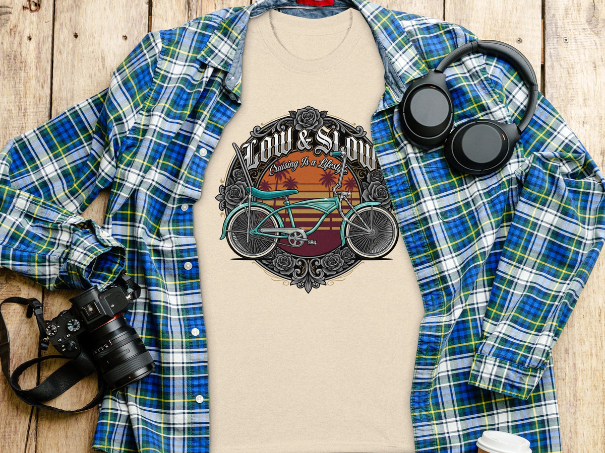 Tan t-shirt with "Low & Slow Cruising Is a Lifestyle" graphic featuring a bicycle and sunset.