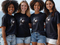Four smiling women wear black t-shirts featuring a graphic of Jesus Christ.
