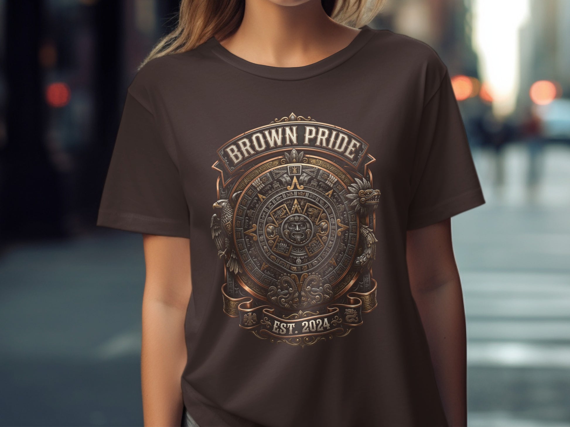 Brown t-shirt with Aztec-style circular emblem and "BROWN PRIDE EST. 2024" text.