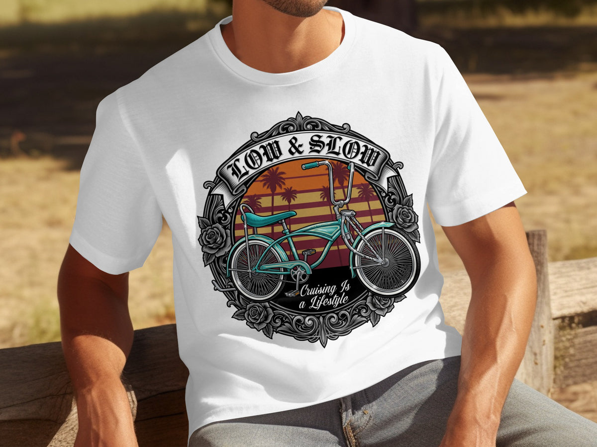 White t-shirt with a graphic of a turquoise lowrider bicycle, palm trees, and text "LOW & SLOW".